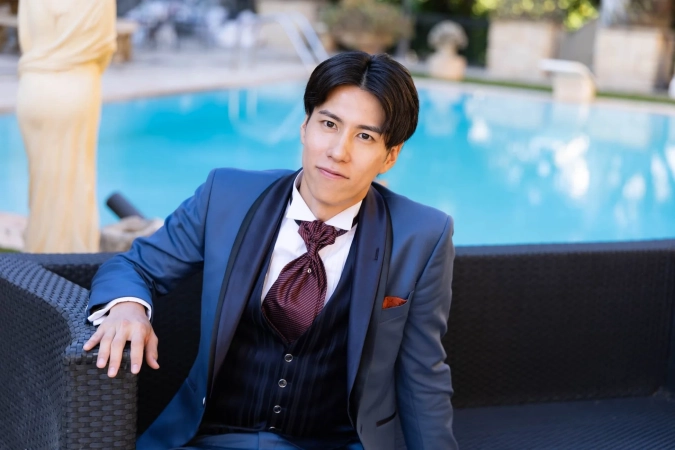 スーツ姿で座るたかしさん