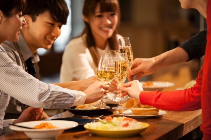 笑顔の若者たちがシャンパンで乾杯しているパーティーの様子