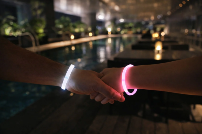 光るブレスレットをつけた手