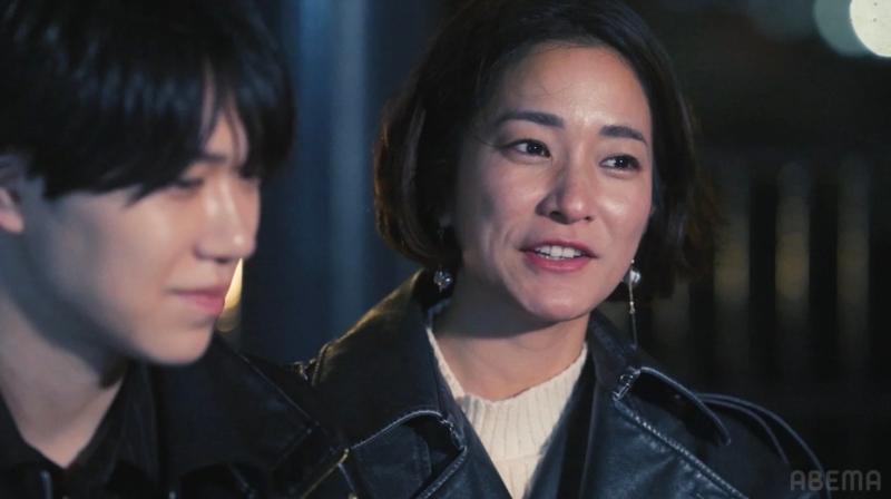 夜景を背景に会話する男女