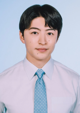 水色の水玉模様のネクタイを着用した白いシャツ姿の若い男性のポートレート。証明写真のようなシンプルな背景と構図で、真面目な印象を与えます。