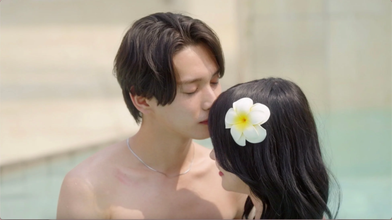 プールサイドで男性が女性のおでこにキスをしている親密な瞬間